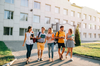 Five friendly students are walking after they passed test outside the college building and discuss the project Free time of a students, bachelor`s campus life rhythm. Five friendly students are walking after they passed test outside the college building and discuss the project, smiling, enjoying, carefree