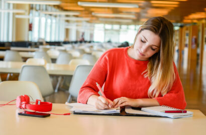 Young student studying in the library. Portrait of young student studying at the university library. Education and lifestyle concept.